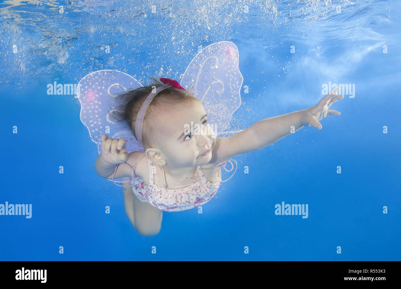 Little baby learns to swims underwater. Baby swimming underwater in the