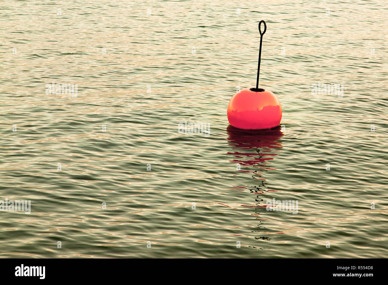 Red bouy on a calm lake - toned image Stock Photo