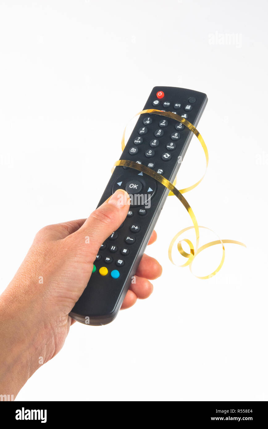 hand holding a remote control in a festive gold ribbon on white