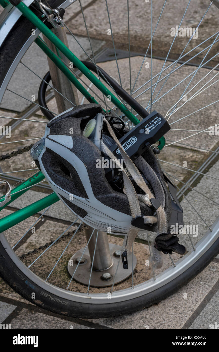 a cycle helmet locked to the front wheel of a bicycle while left by the