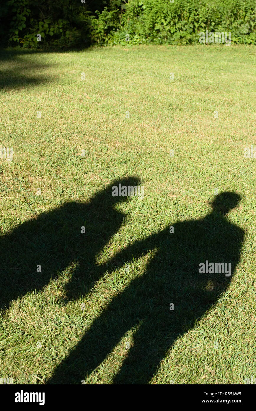 Shadows of a couple on a lawn Stock Photo - Alamy