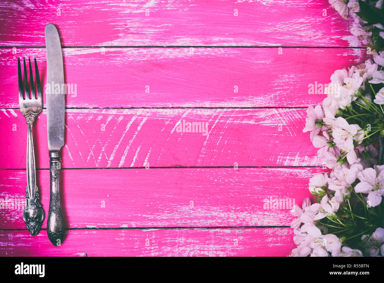 Iron fork and knife on a pink wooden background, empty space in the ...