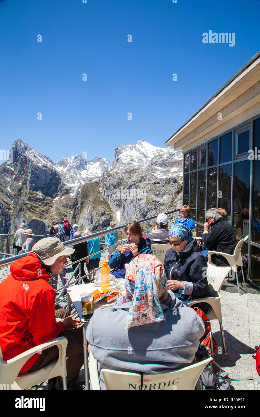 People sitting eating and drinking at the cafe at the top of Fuente De after taking the cable car up the mountain in the Picos de Europa Spain Stock Photo