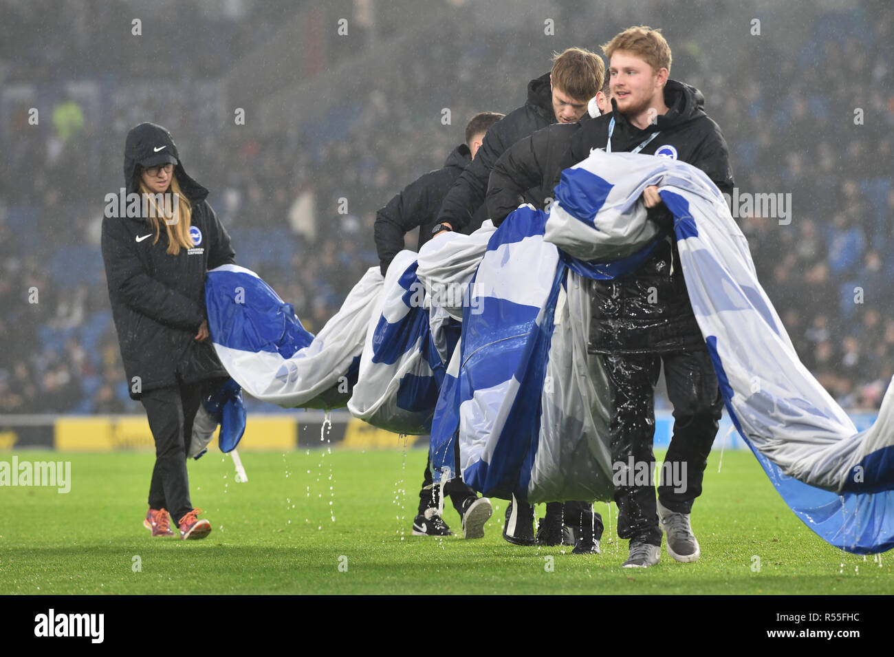 It's heavy work for the ground staff in the rain during the Premier League match between Brighton and Hove Albion and Leicester City at American Express Community Stadium , Brighton , 24 November 2018 Editorial use only. No merchandising. For Football images FA and Premier League restrictions apply inc. no internet/mobile usage without FAPL license - for details contact Football Dataco Stock Photo