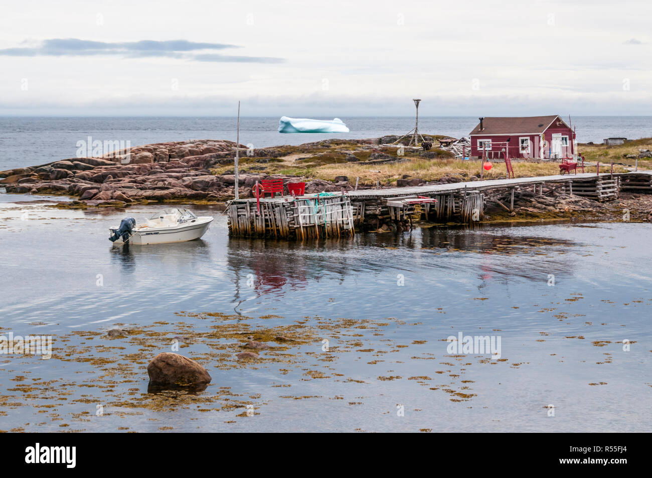 Iceberg floating past the small Labrador town of West Saint Modeste. Stock Photo