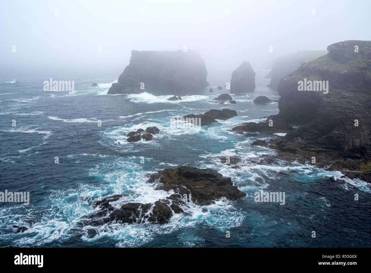 Sea stacks and sea cliffs in mist during stormy weather at Eshaness / Esha Ness, peninsula in Northmavine, Mainland, Shetland Islands, Scotland, UK Stock Photo