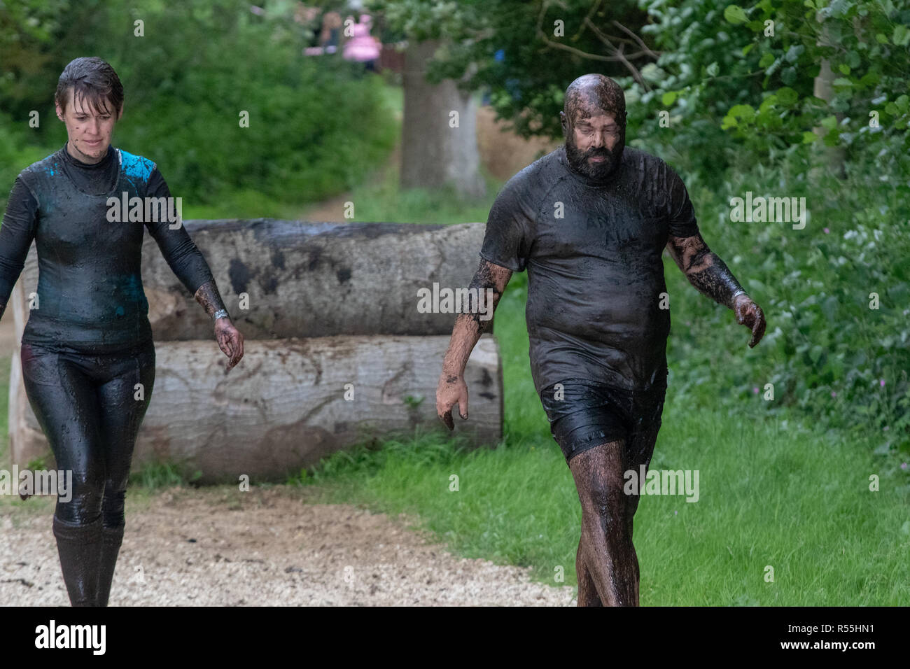 Man and woman covered in mud at a mud run Stock Photo