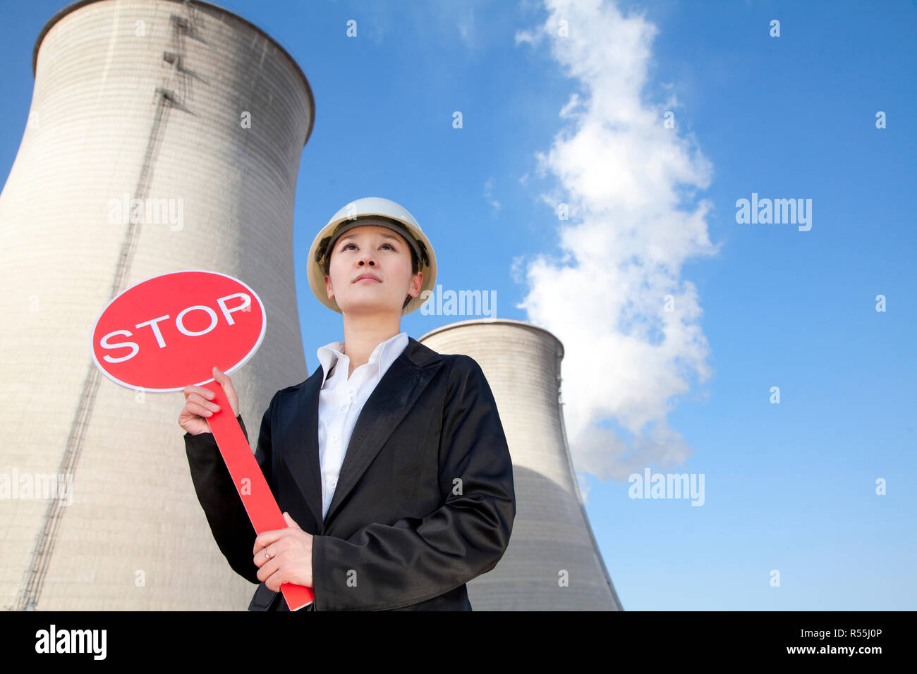 Engineer in front of cooling towers with stop sign Stock Photo - Alamy