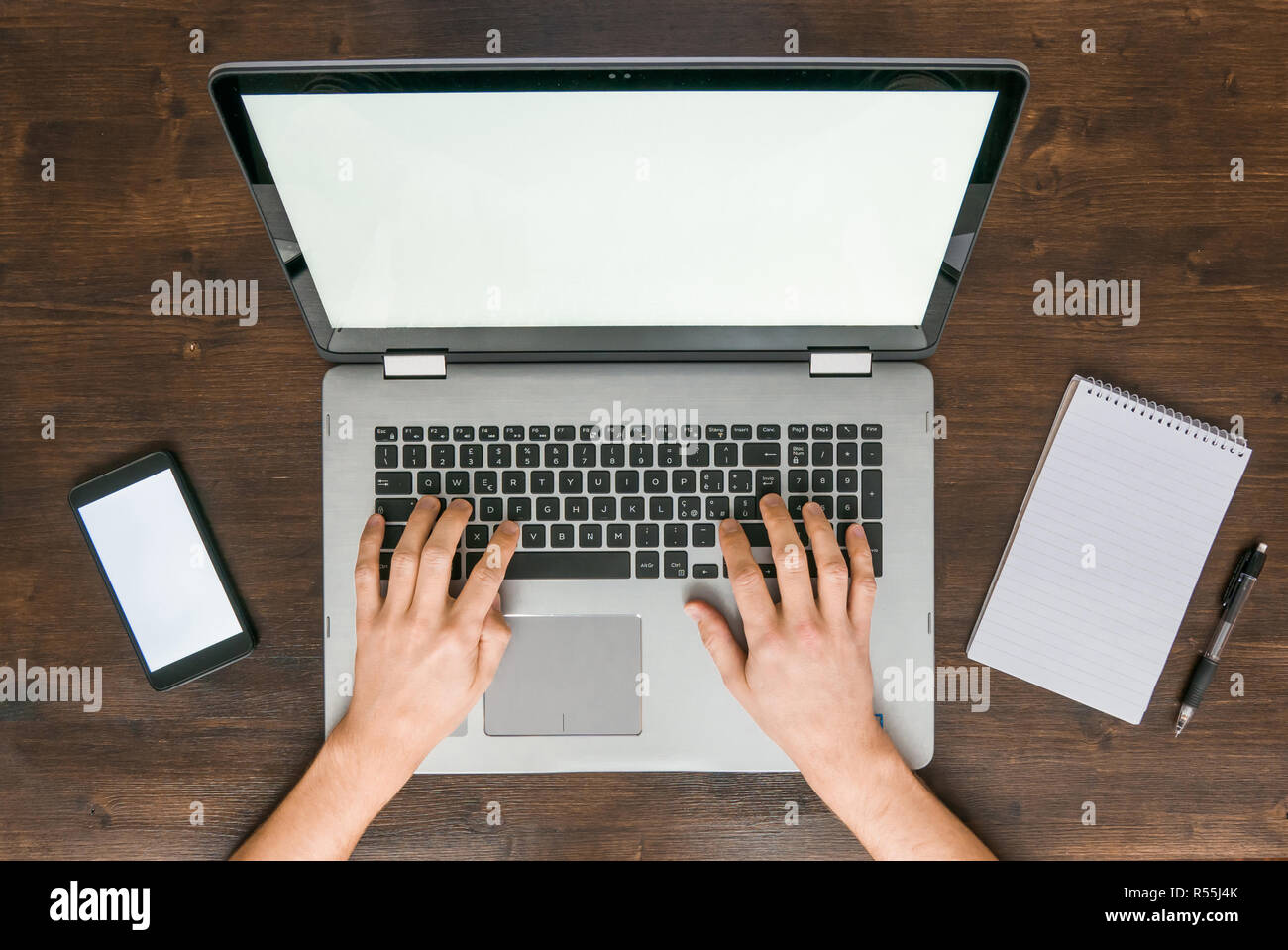 Top view of man working on laptop computer on brown wooden desk Stock ...