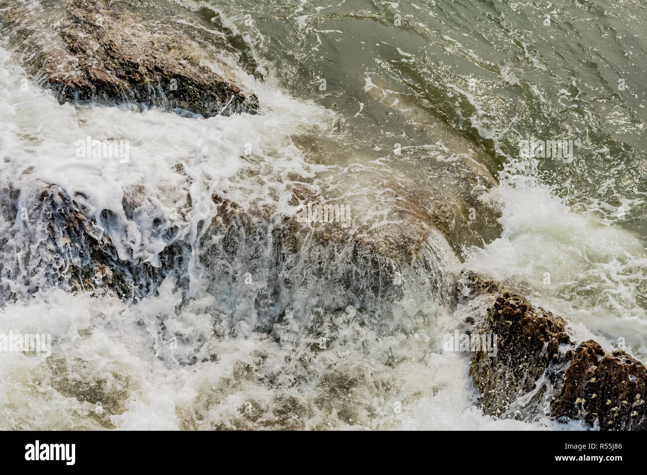ocean water waves crashing onto the shore rocks and stones with white ...