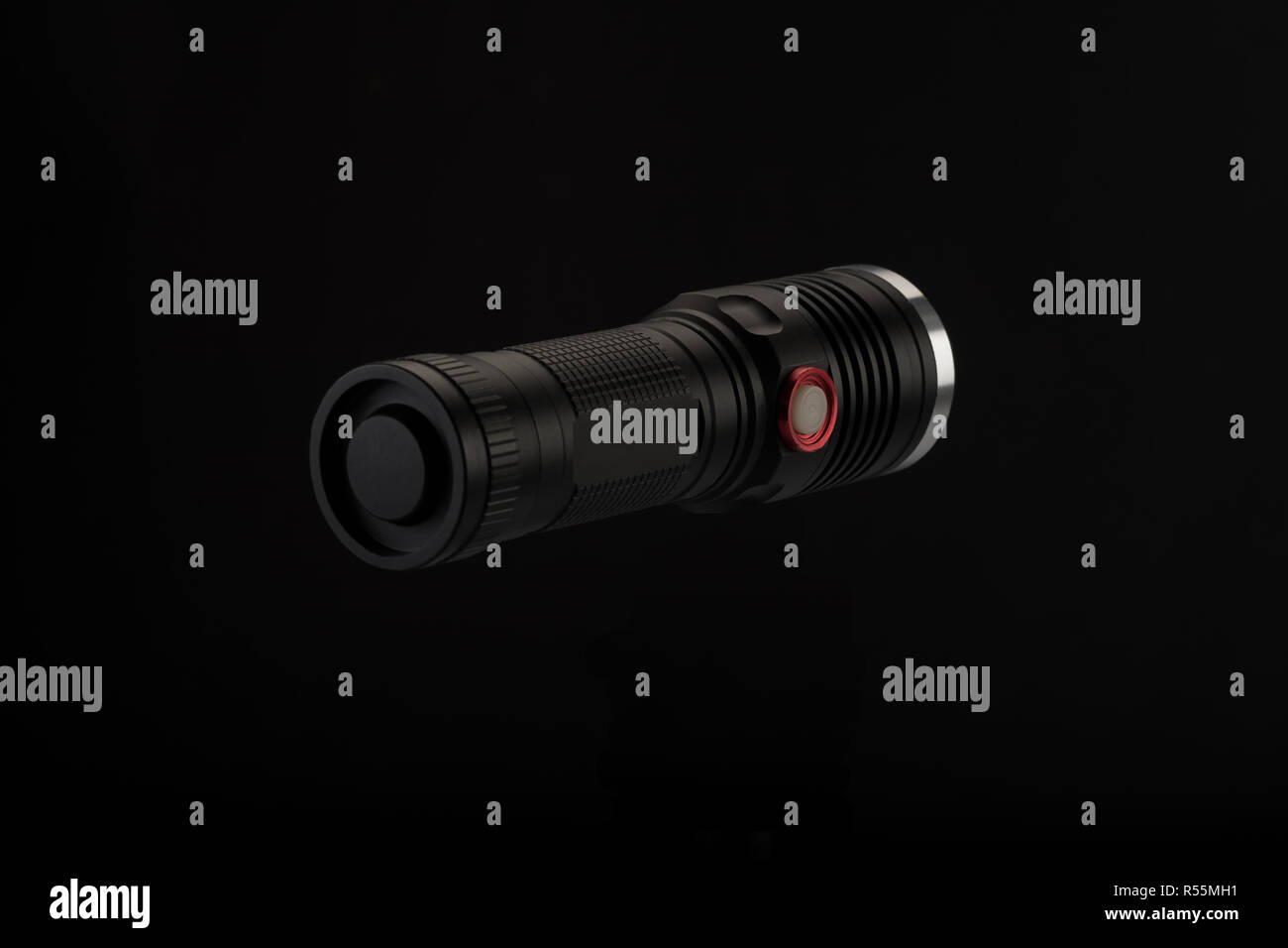 Tactical flashlight, hand on black background, studio light Stock Photo