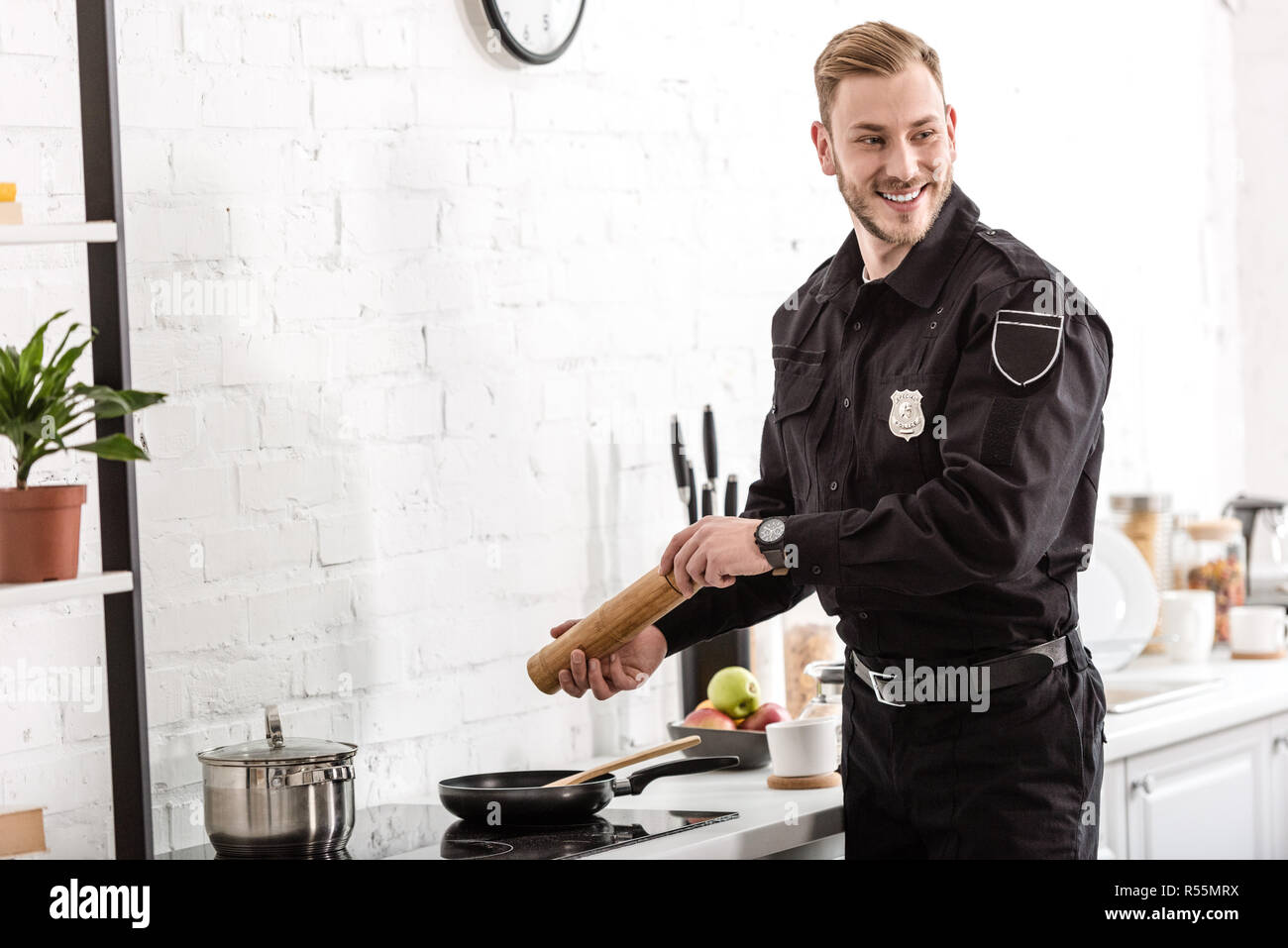police officer smiling and cooking breakfast at kitchen Stock Photo Alamy