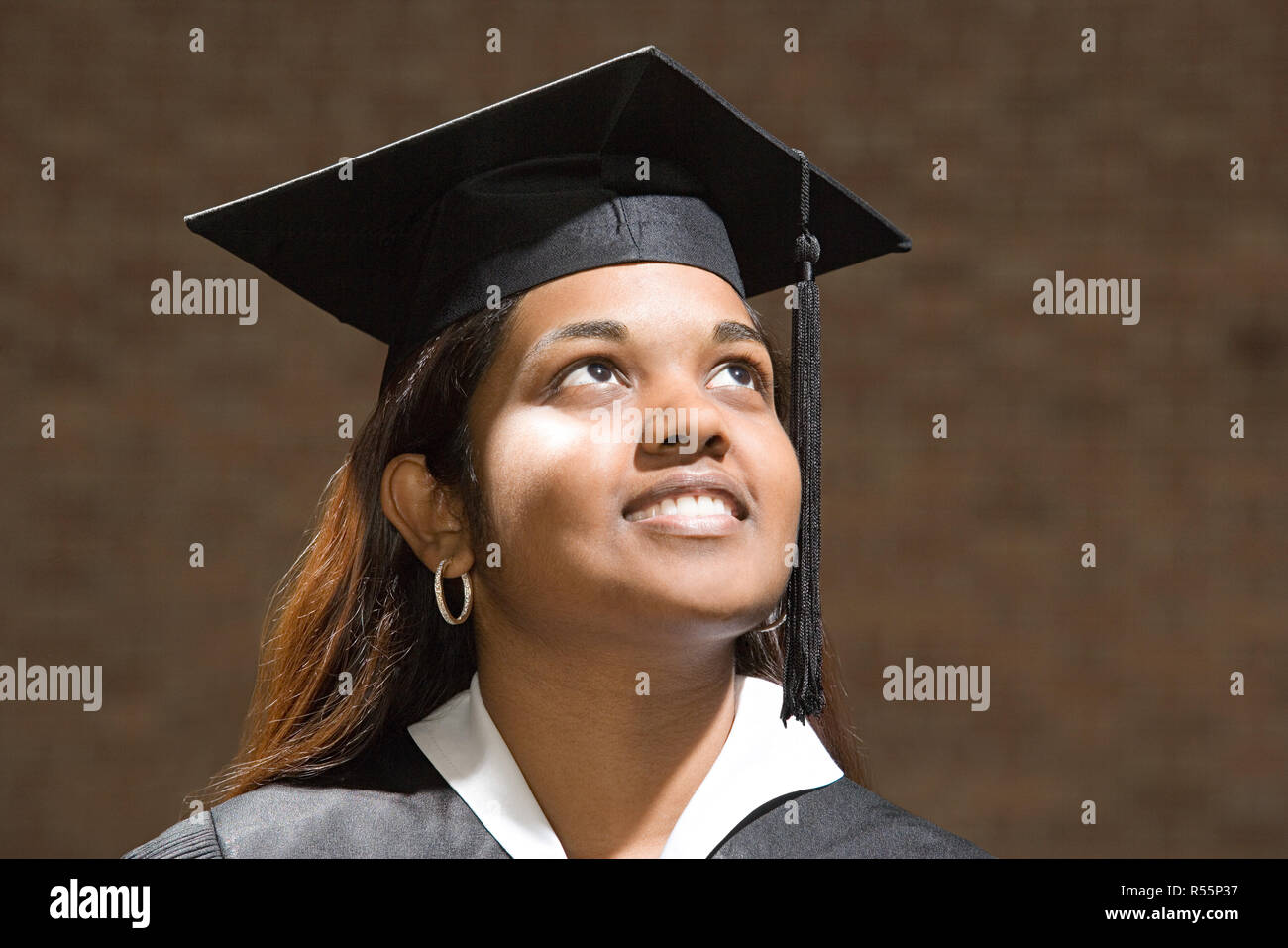 Female graduate looking up Stock Photo