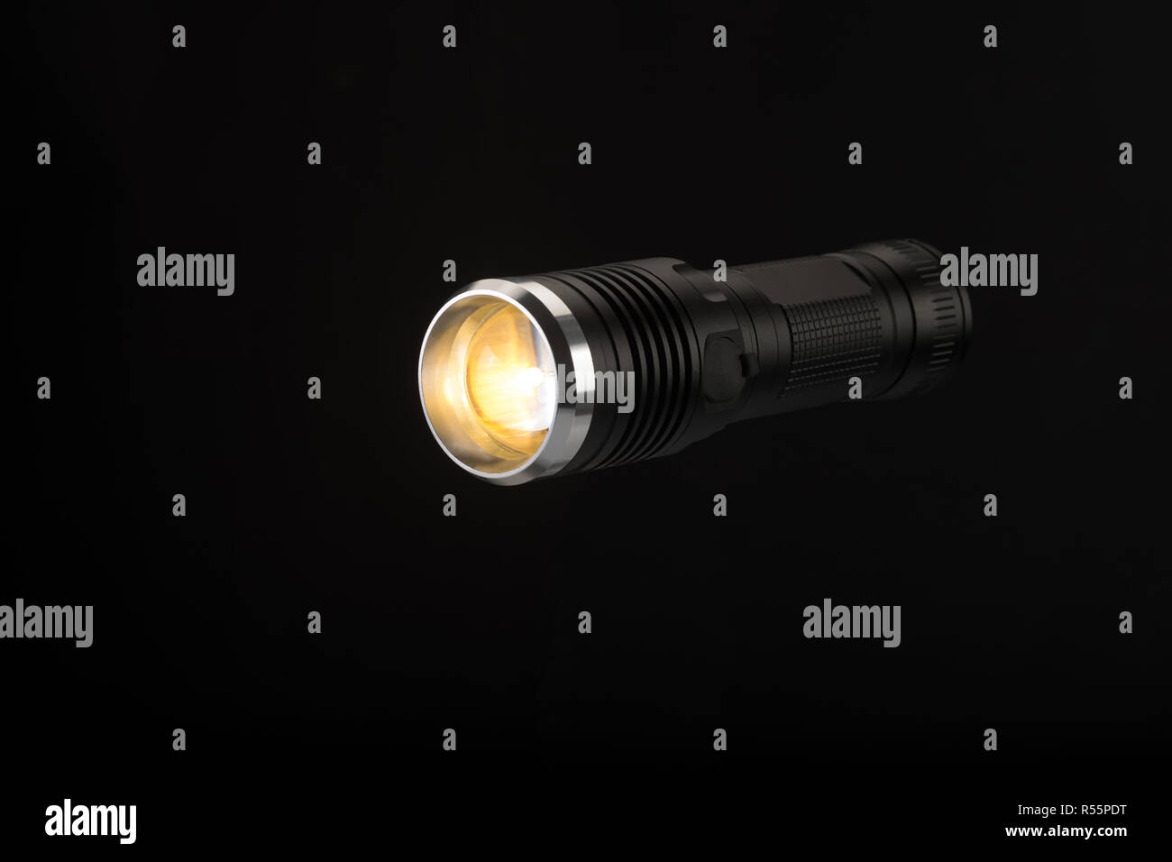 Tactical flashlight, hand on black background, studio light Stock Photo