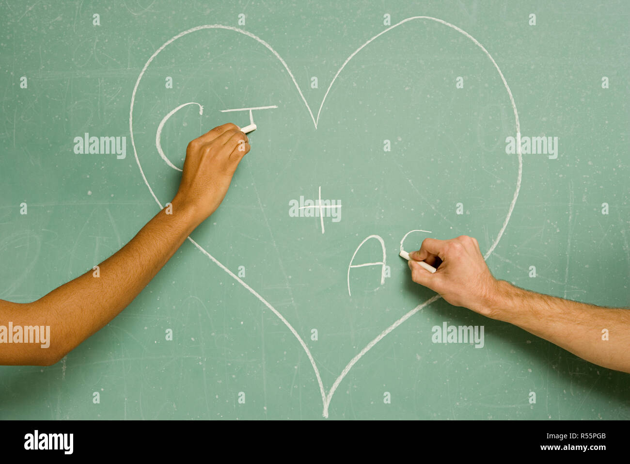 Two students drawing on a blackboard Stock Photo