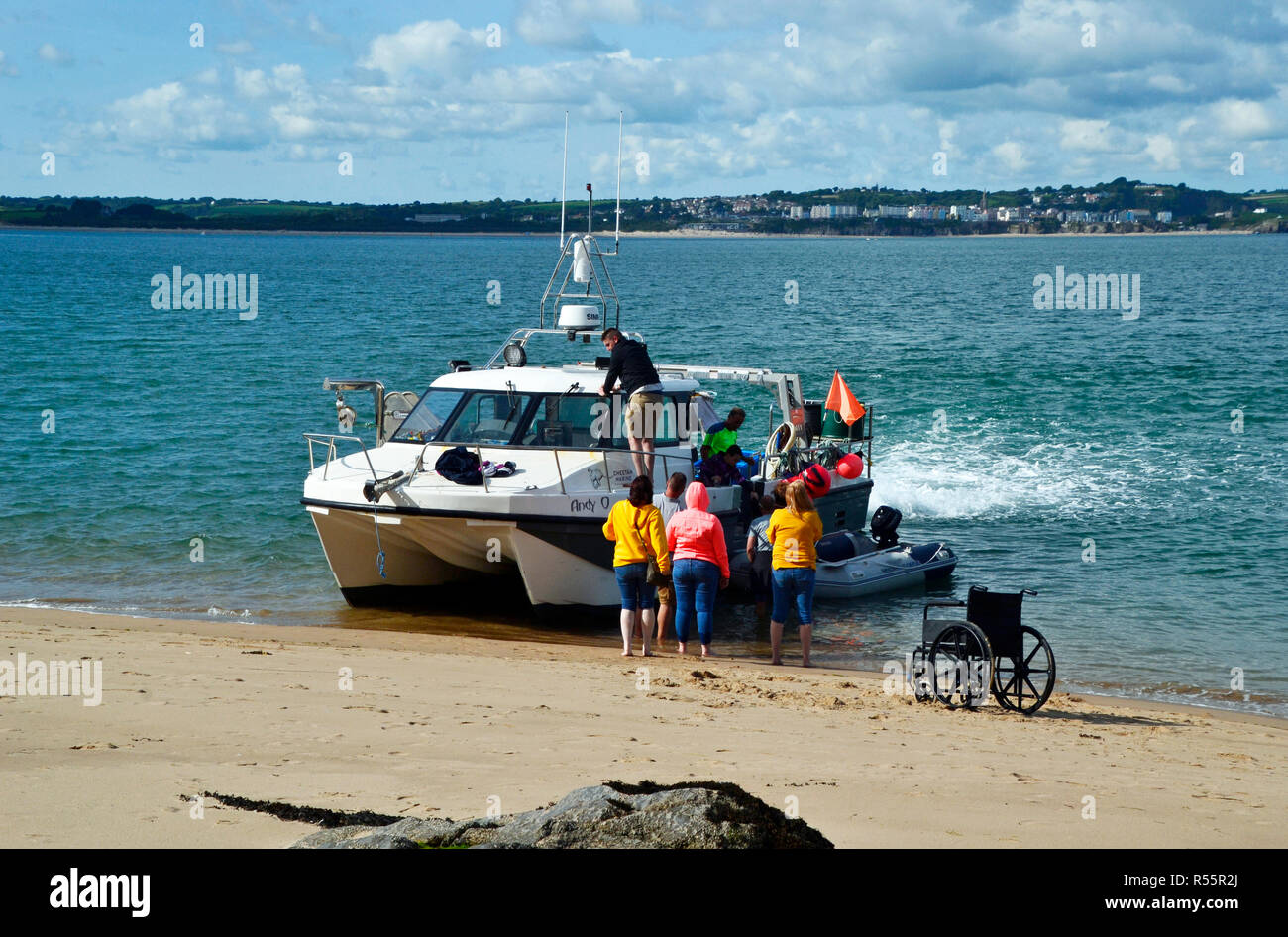 Disabled person manouvring from wheelchair to boat on Caldey Island, near Tenby, Wales, UK Stock Photo