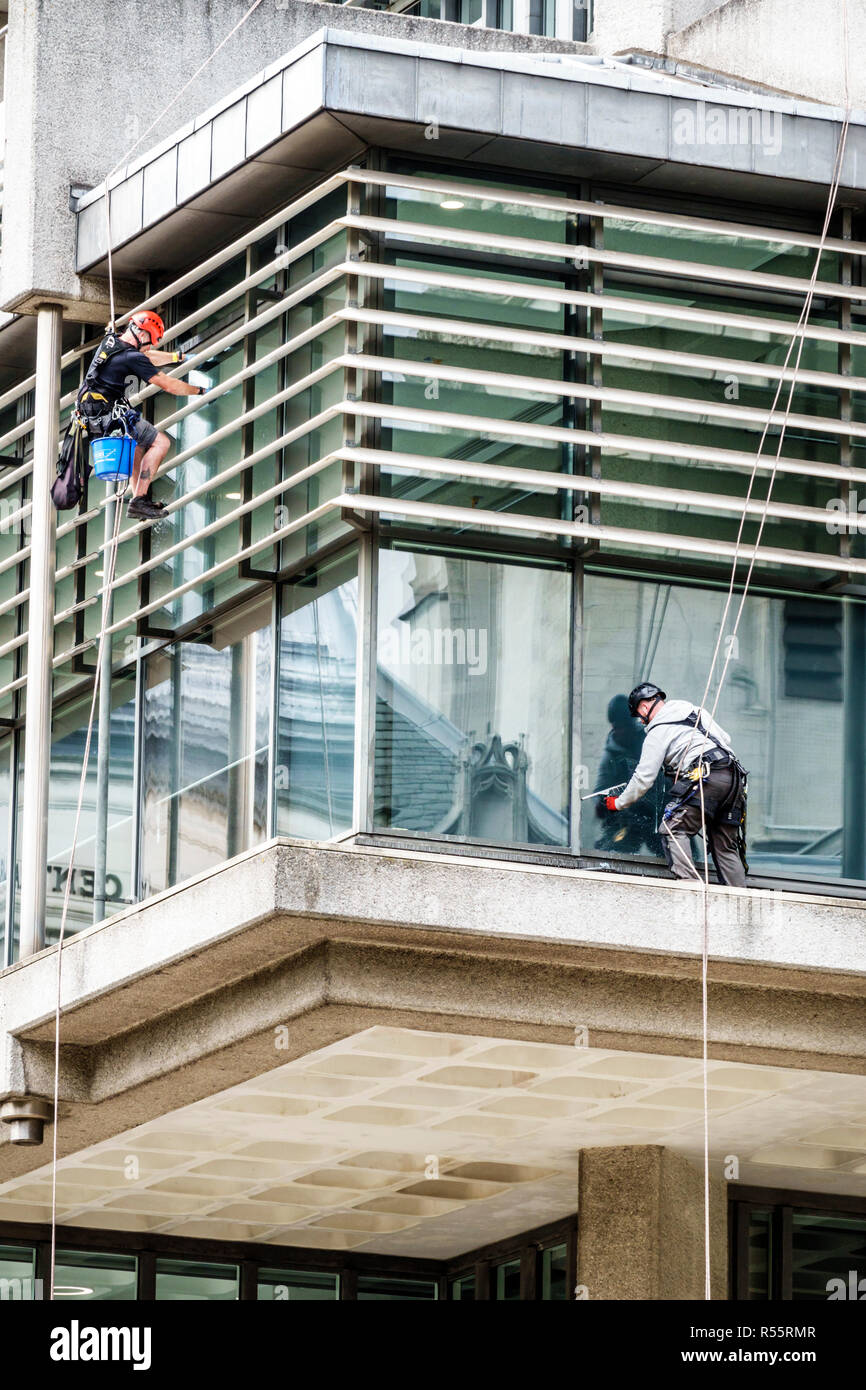 London England,UK,Westminster,modern office building,exterior,glass window cleaners,man men male,worker,working,cleaning,dangerous,safety fall protect Stock Photo