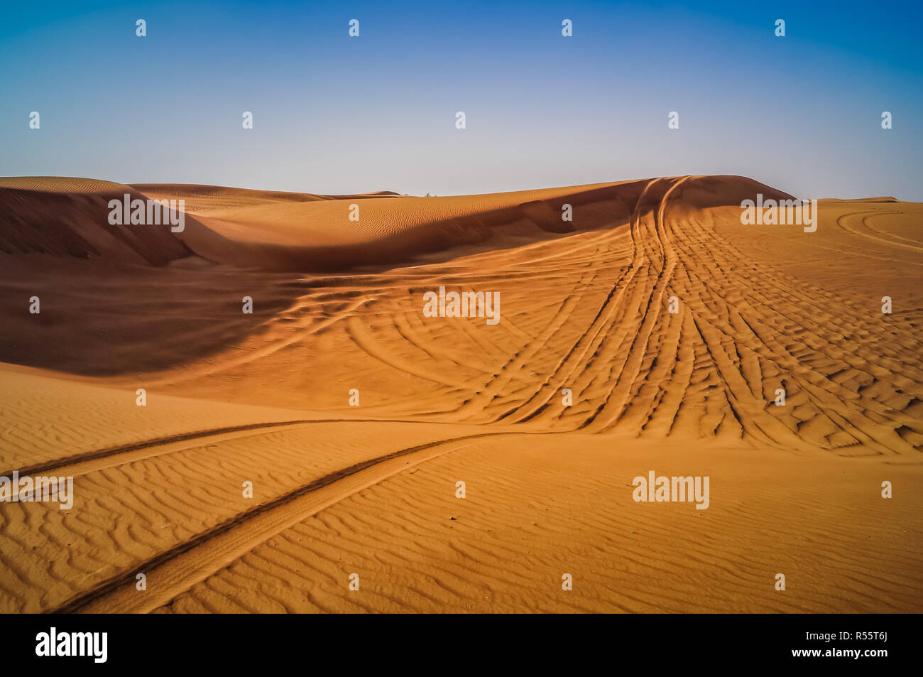 Tire tracks through the desert sand dunes. Feeling lost and alone in