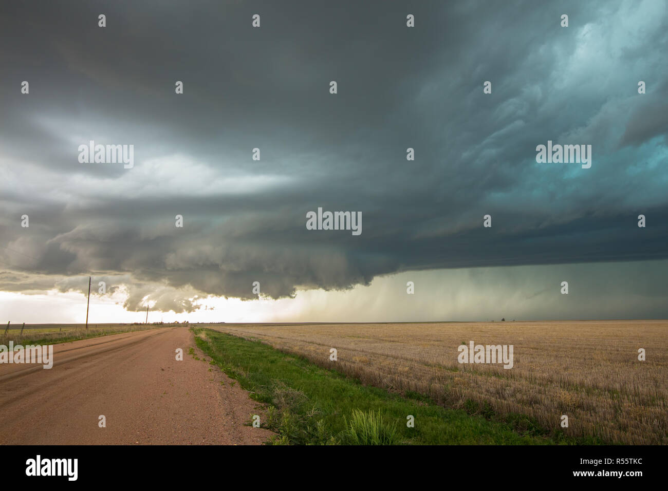 A wall cloud forms underneath a tornadic supercell thunderstorm as it gathers strength. Stock Photo