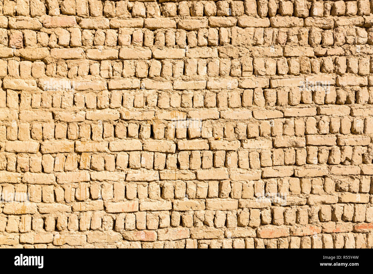 Ancient islamic Arabic muslim old town house wall built of yellow brown mud bricks on sunny day texture. Al Qasr, Dakhla Oasis, Western Desert, Egypt. Stock Photo