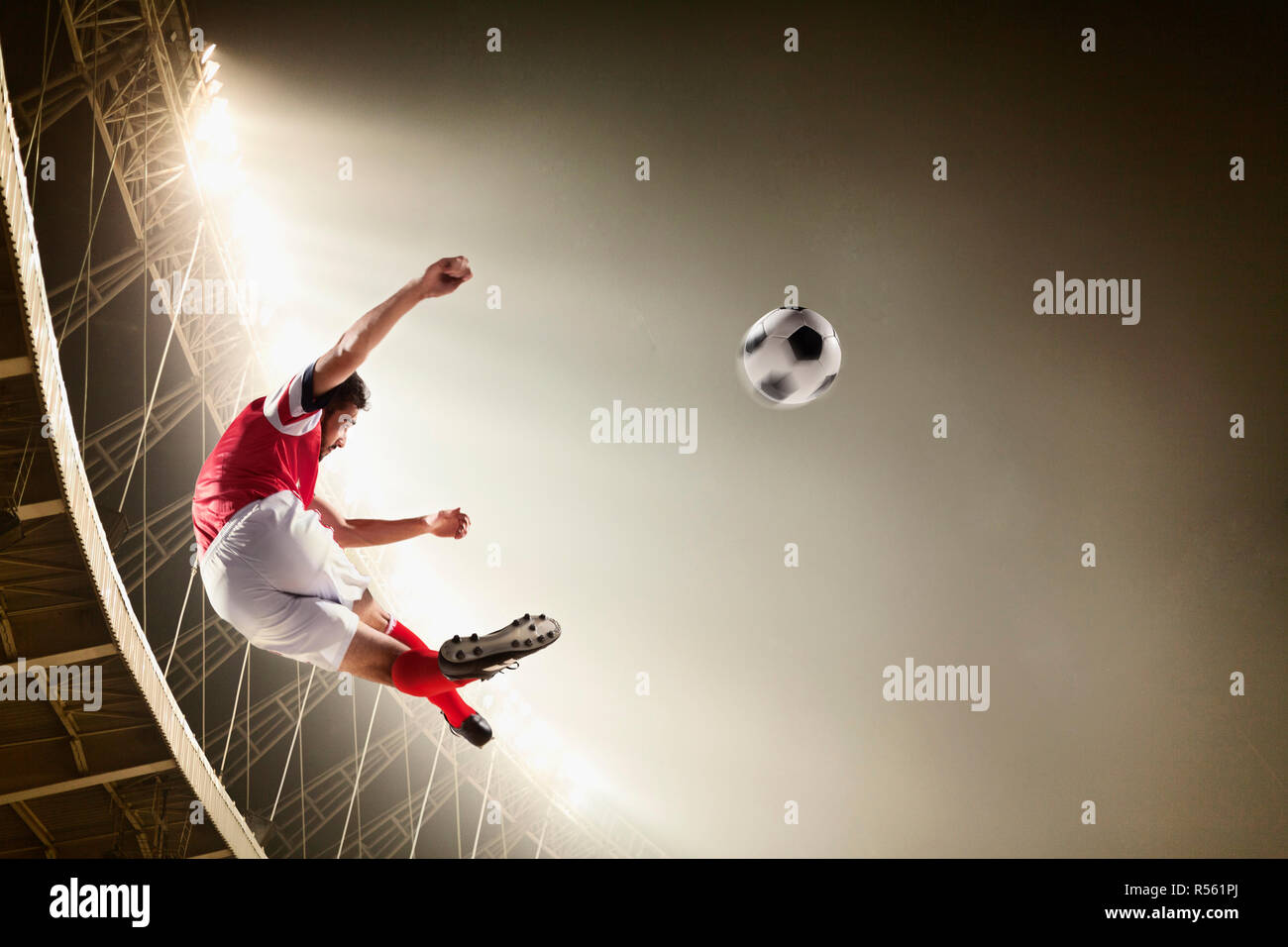 Athlete kicking soccer ball in stadium Stock Photo - Alamy