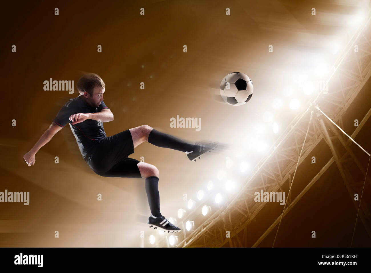 Athlete kicking soccer ball in stadium Stock Photo - Alamy
