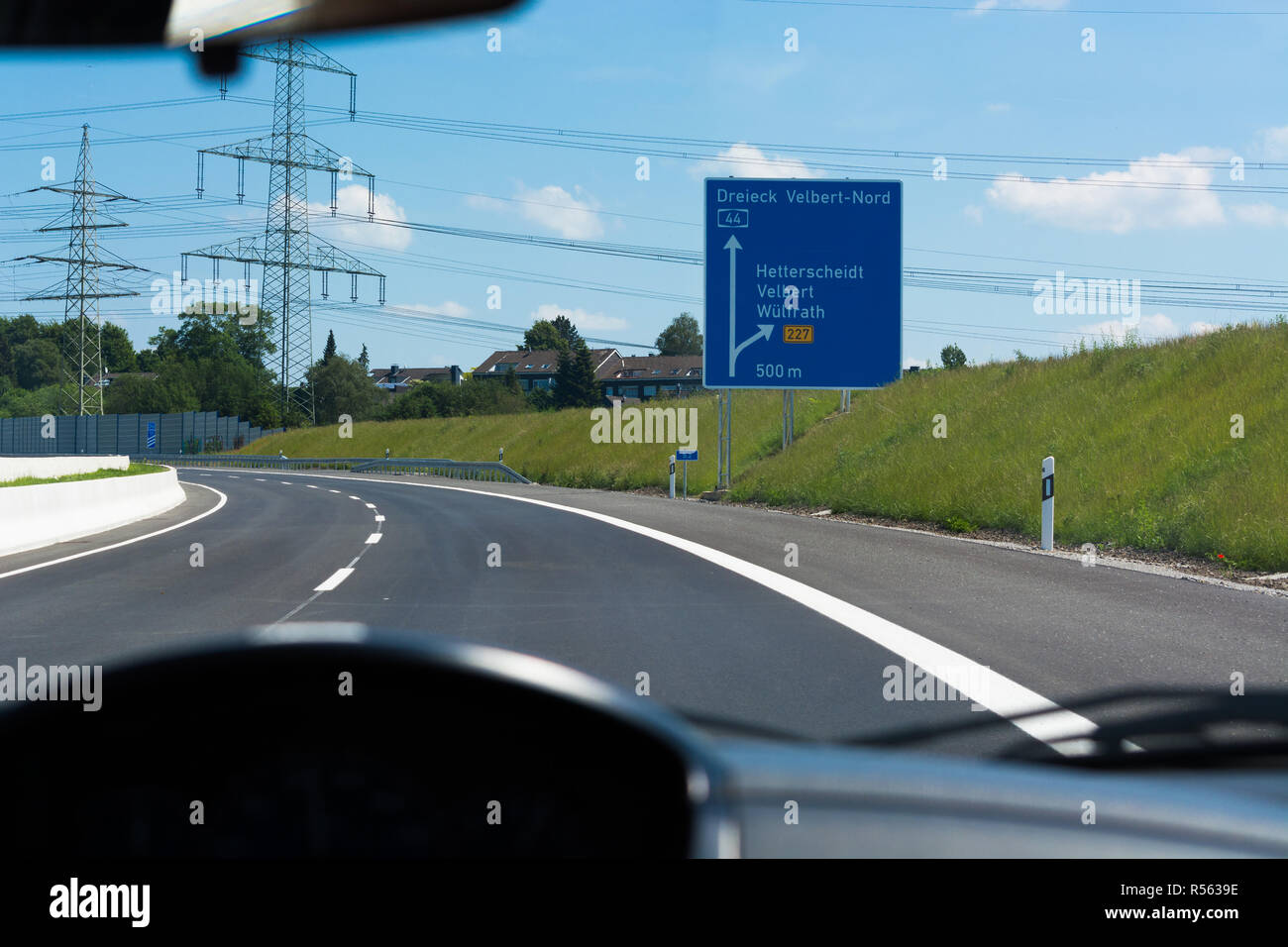 German motorway sign with inscription in German Driving direction to the cities - Velbert, Heiligenhaus, Wuelfrath and Hetterscheidt Stock Photo