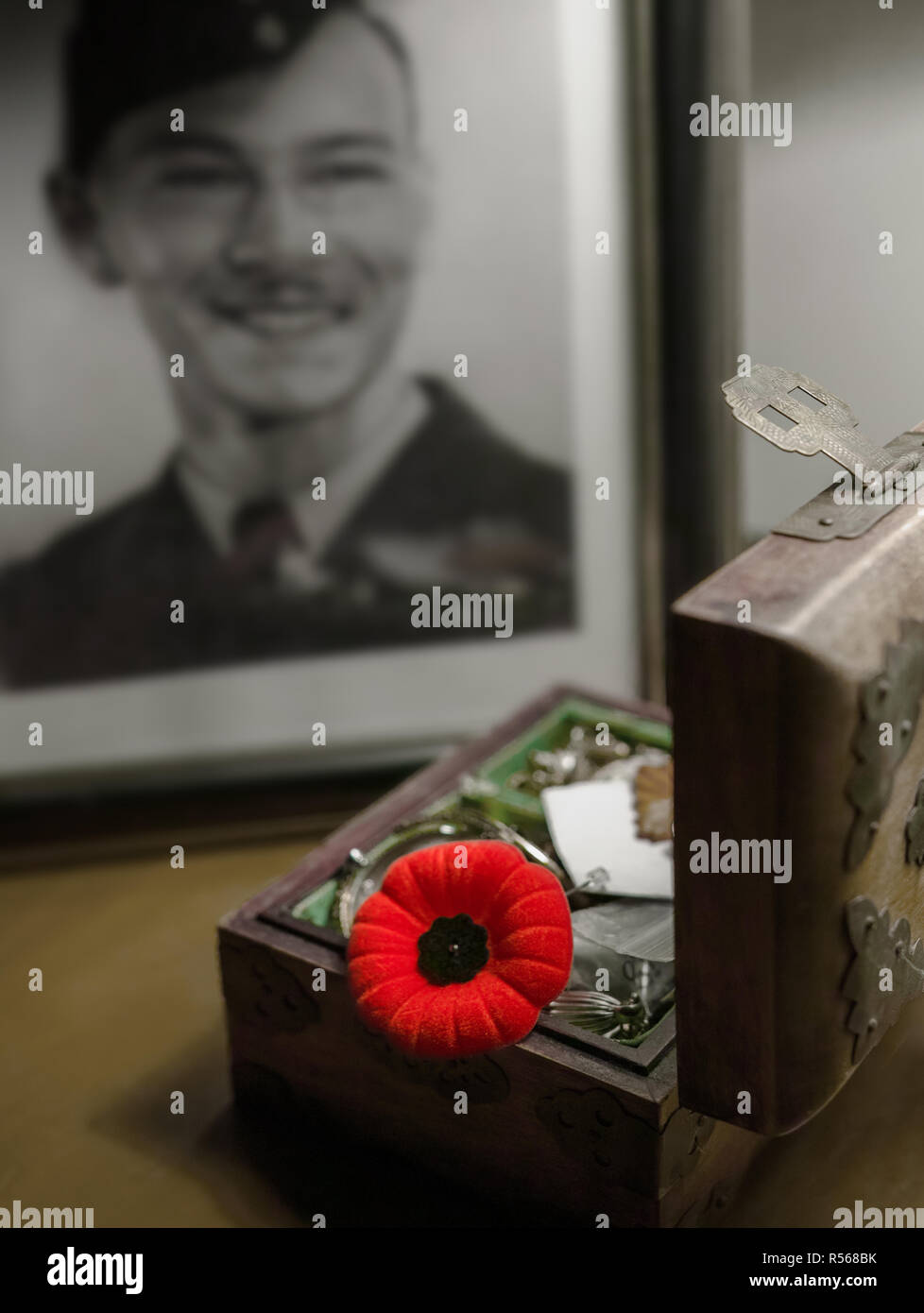 We see in the background the portrait of the disappeared soldier. In front, in the opened jewelry box someone also keeps a poppy. Stock Photo