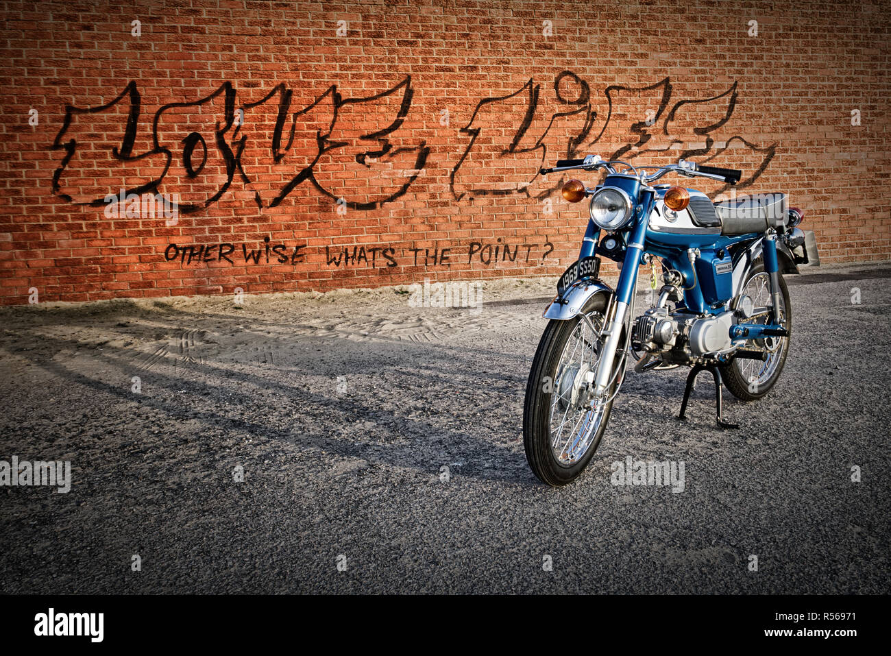 1969 Honda SS50 50cc classic moped or motorcycle Sixteener special with background graffiti on a wall quote love life otherwise whats the point! Stock Photo