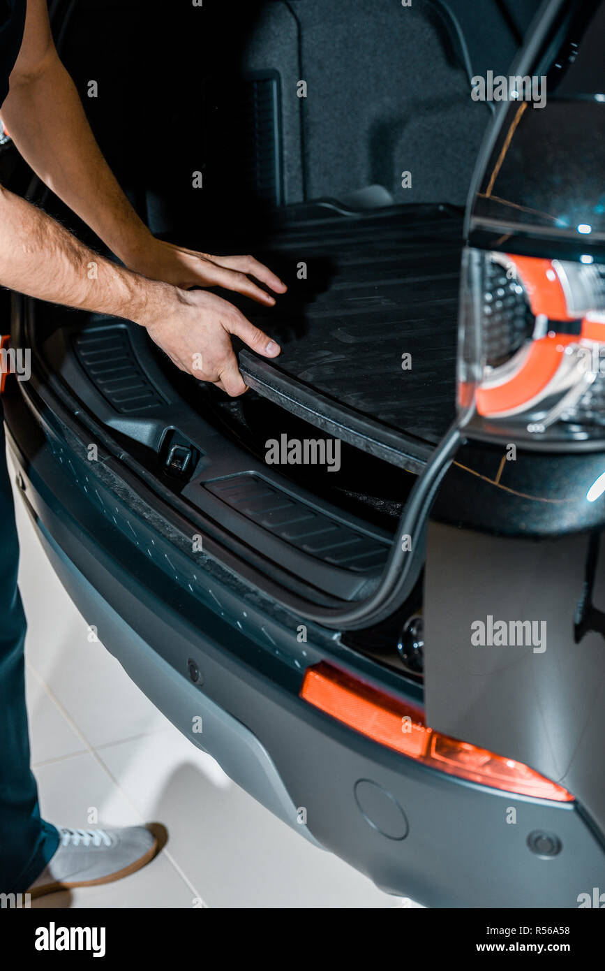 partial view of auto mechanic checking car trunk at auto repair shop Stock Photo