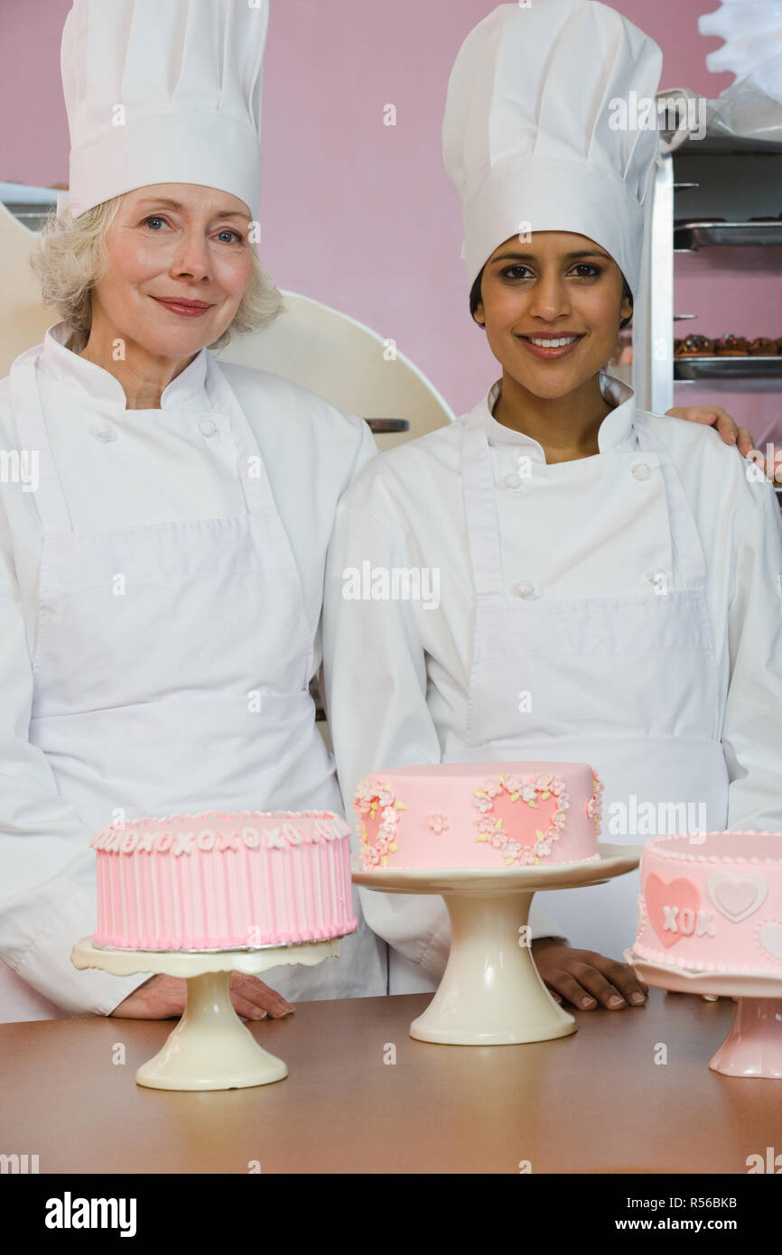 Mixed Race female pastry chef holding cake Stock Photo - Alamy