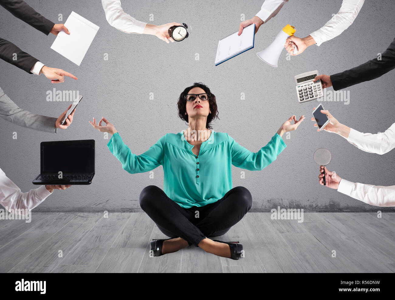 Businesswoman tries to keep calm with yoga due to stress and overwork at wok Stock Photo