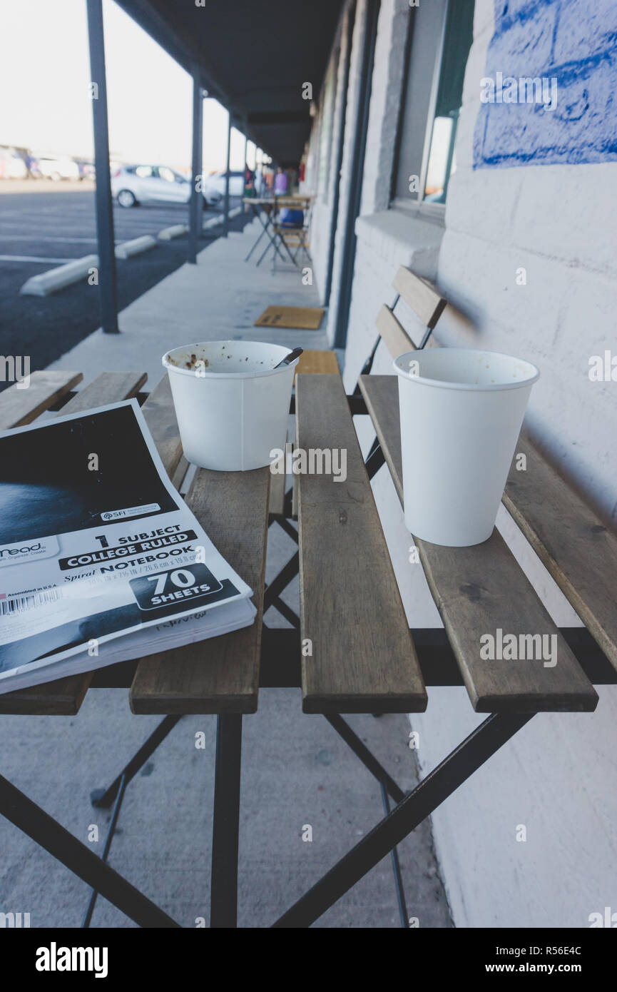 Journaling in a notebook over complimentary coffee and breakfast in the morning at an American motel during a road trip Stock Photo