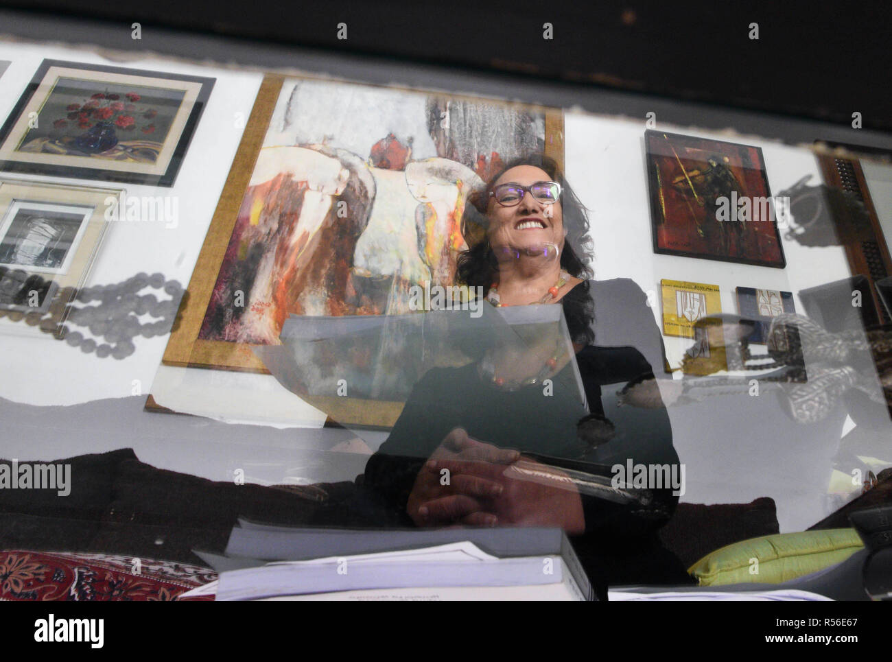 November 17, 2018 - Tunis, Tunisia: Reflection of Bochra Belhaj Hmida on the mirror of her coffee table.  Bochra Belhaj Hmida is a Tunisian lawyer and feminist activist who chaired the COLIBE committee in charge of making propositions on how to improve individual rights in Tunisia. Tunisian politicians are debating a new law inspired by COLIBE to give both sexes equal inheritance rights, which would reform the current Islamic-inspired code that ensures that a man receives double a womanÕs share of an inheritance. Portrait de Bochra Belhaj Hmida, militante historique des droits des femmes et pr Stock Photo