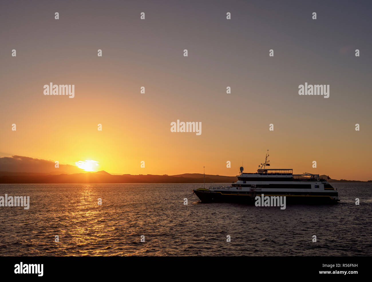 National Geographic Islander Cruise Ship at sunset, Santiago or James Island in the background, Galapagos, Ecuador Stock Photo
