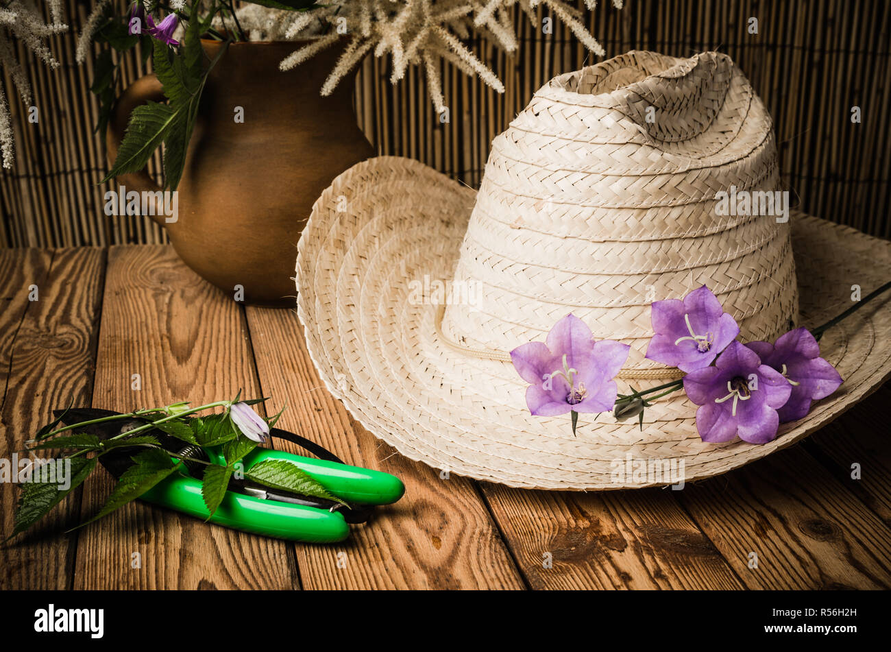Straw hat and flowering campanula, close-up Stock Photo