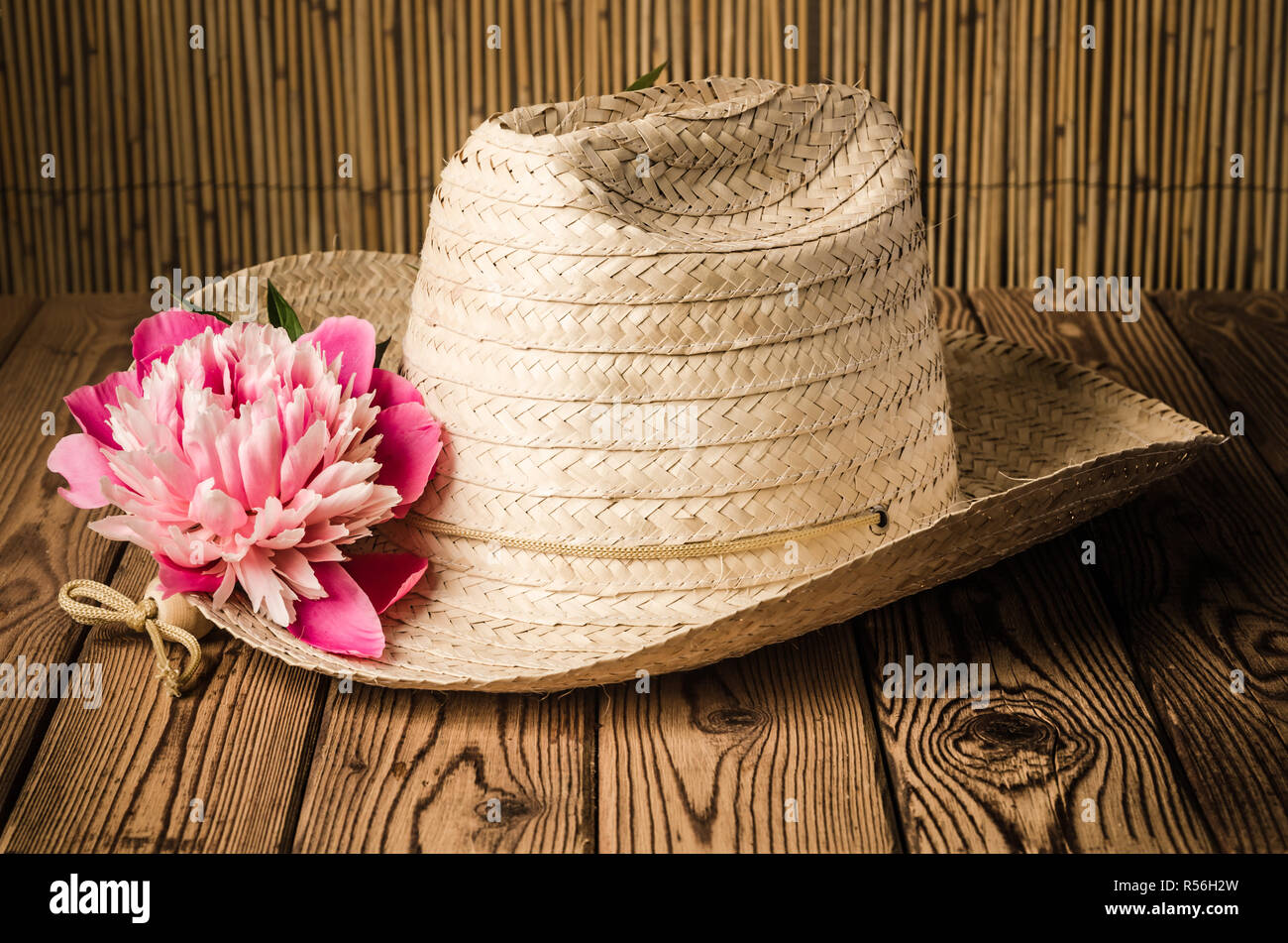 Straw hat and peony flower, close-up Stock Photo