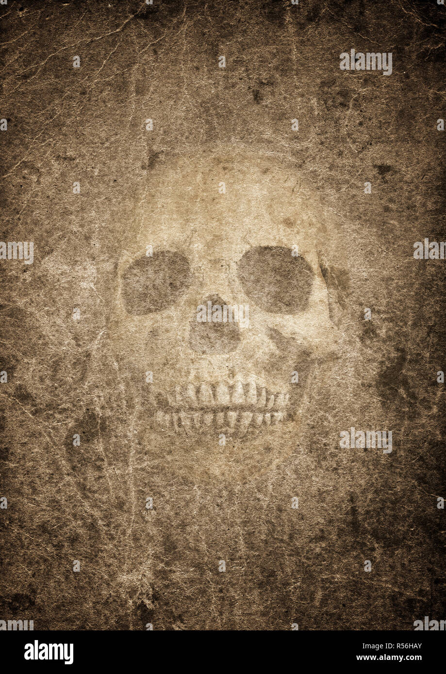 Very old burnt grunge textured paper with human skull Stock Photo