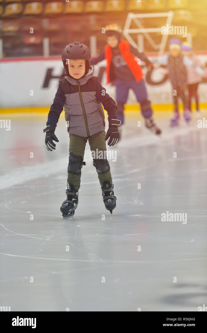 Adorable little boy in winter clothes with protections skating on ice rink Stock Photo Alamy