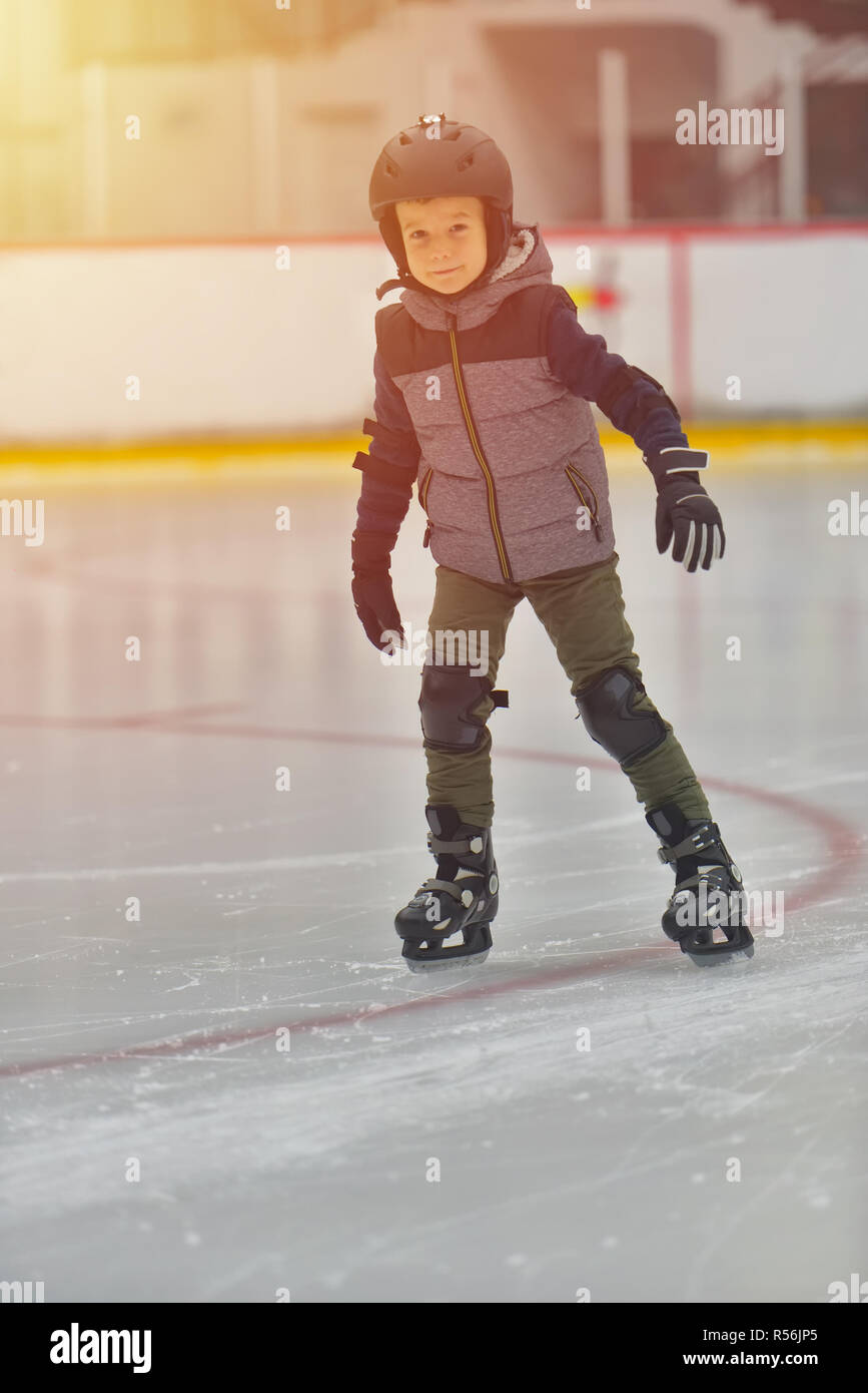 Adorable little boy in winter clothes with protections skating on ice rink Stock Photo Alamy