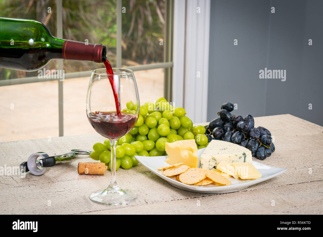 Glass of red wine with wine bottle, cheese, crackers, ham, almonds and grapes Stock Photo Alamy