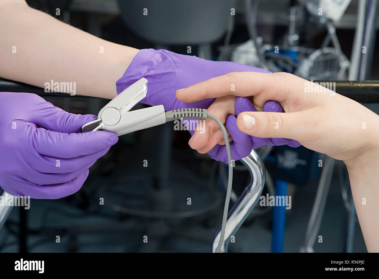 Surgeon putting finger clip on patient Stock Photo Alamy