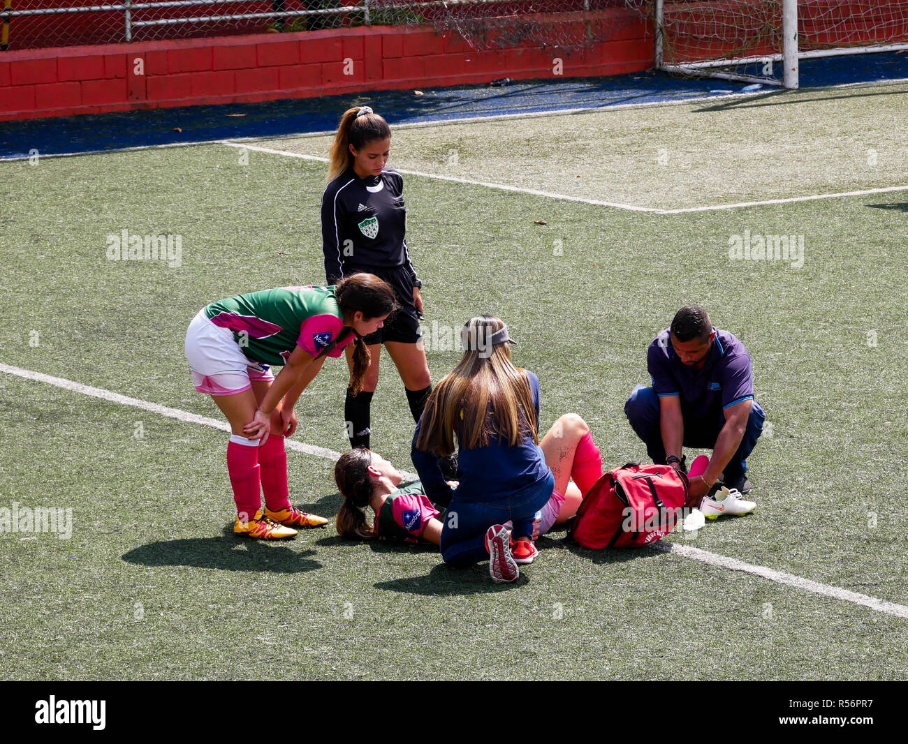 paramedics helping a girl injured on her ankle during a soccer