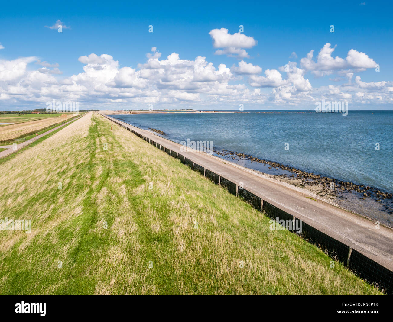 Dike with grass protecting polders on West Frisian island Texel against Wadden Sea, Netherlands Stock Photo