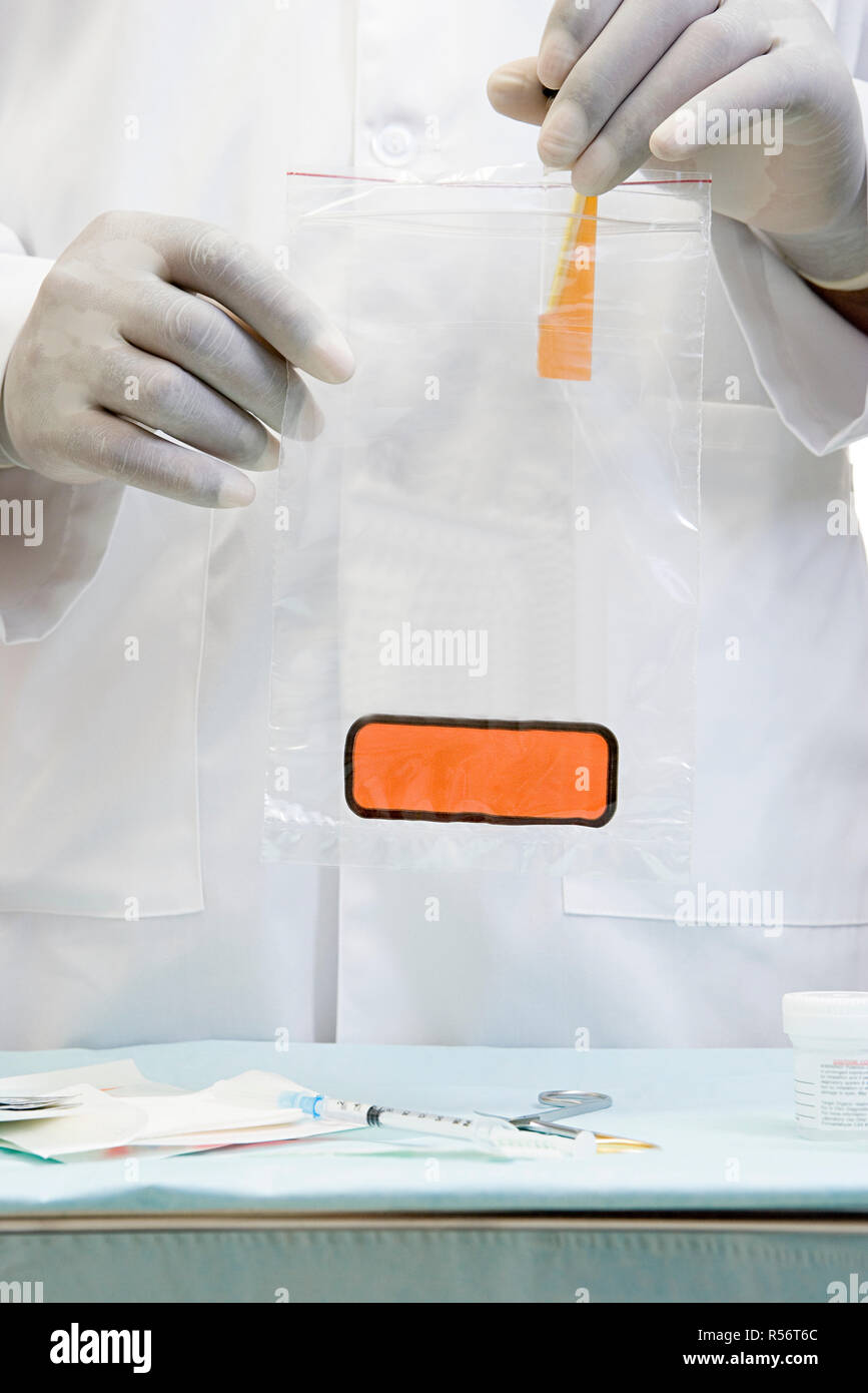Doctor putting a sample in biohazard bag Stock Photo