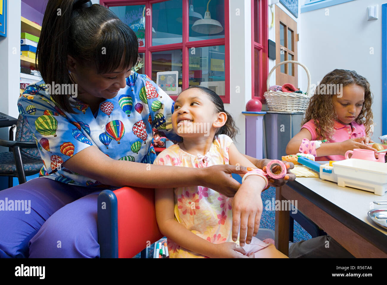 Nurse bandaging girls arm Stock Photo - Alamy