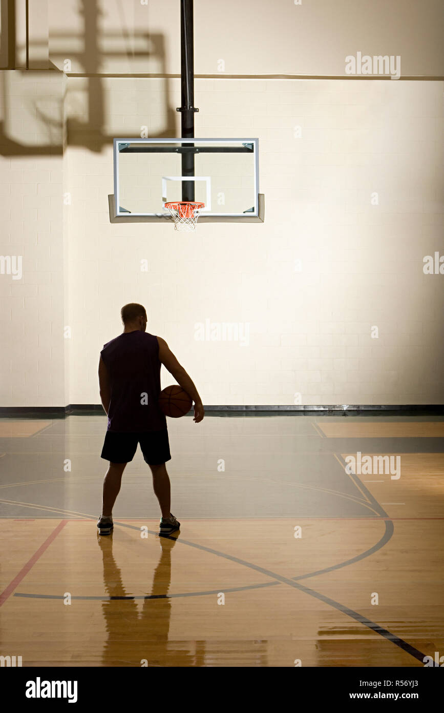 Basketball player alone in basketball court Stock Photo Alamy