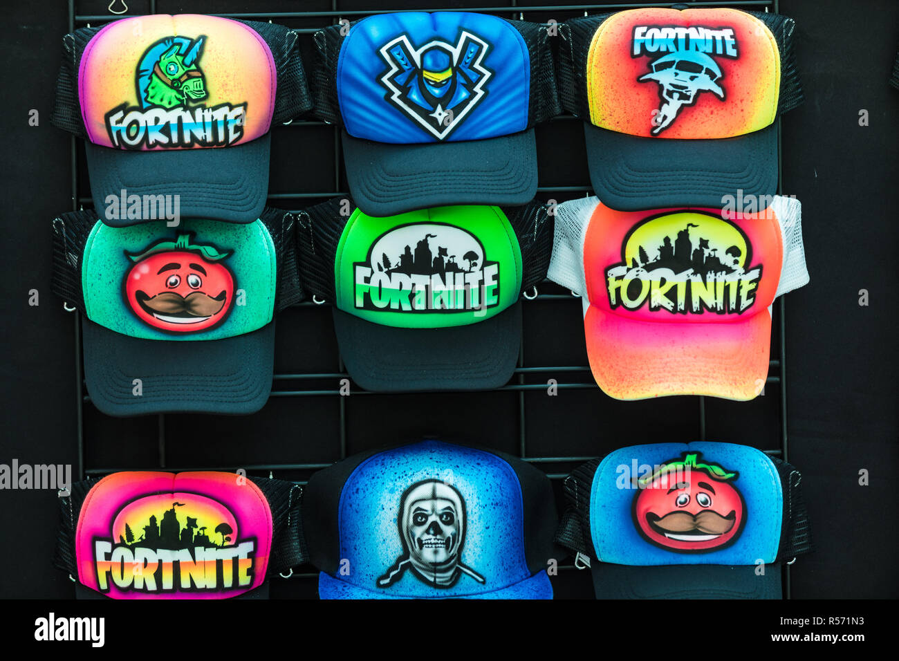 Colourful airbrushed caps with a Fortnite design.  Fortnite is a popular video game. Stock Photo