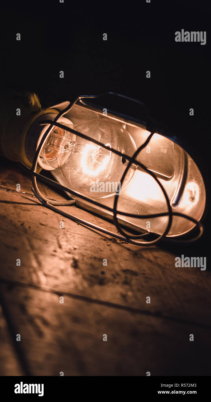 Light bulb in metal case on tiles in car mechanic Stock Photo