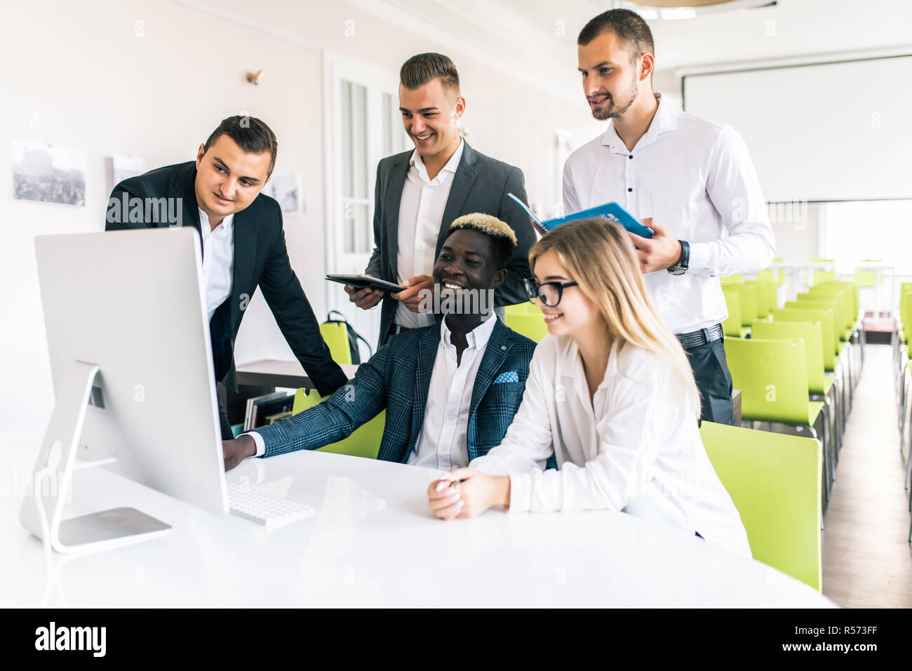 Young professionals work in modern office.Project manager team discussing new idea.Business crew working with startup.Desktop computer table,showing p Stock Photo